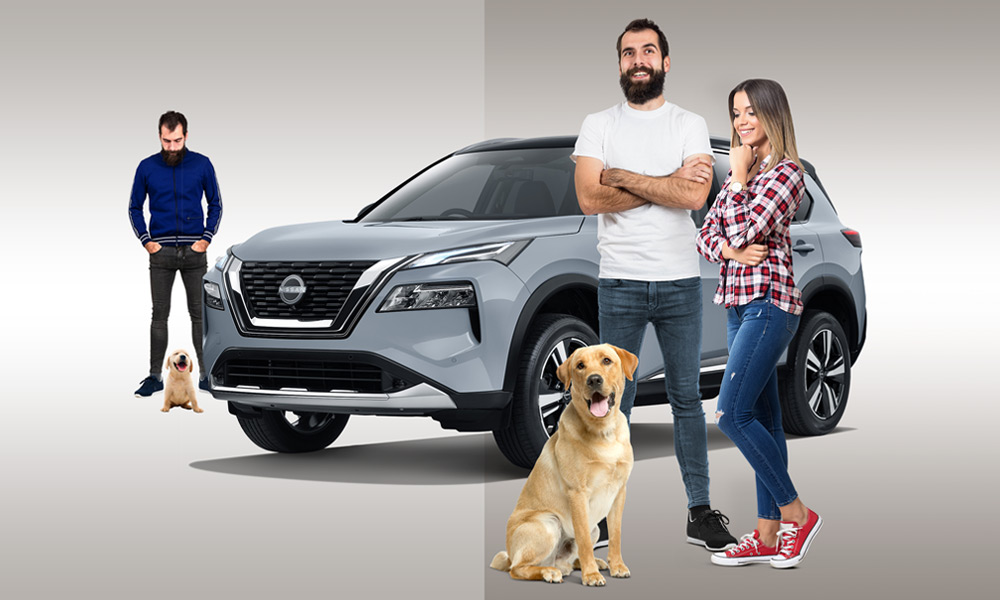 A male/female couple with a dog infront of a Nissan X-Trail