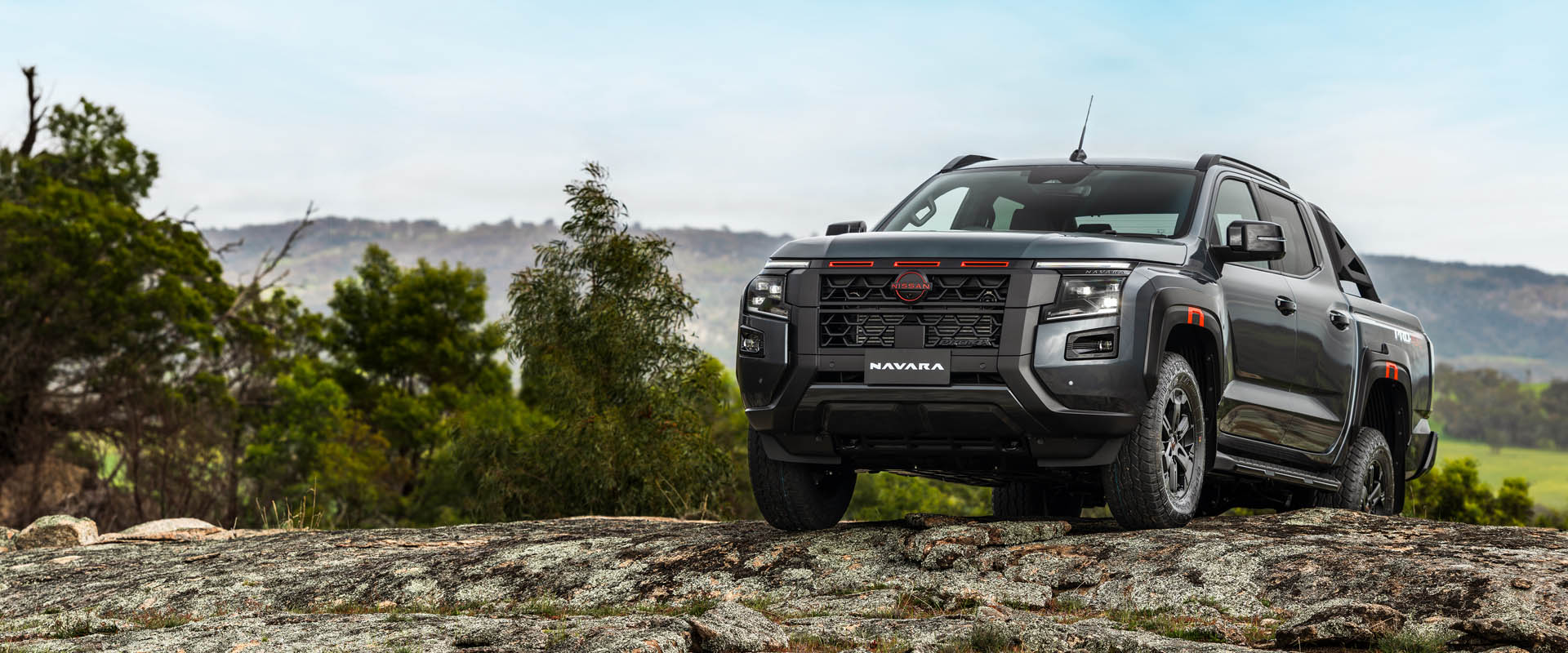 A dark grey Ute parked on a hill