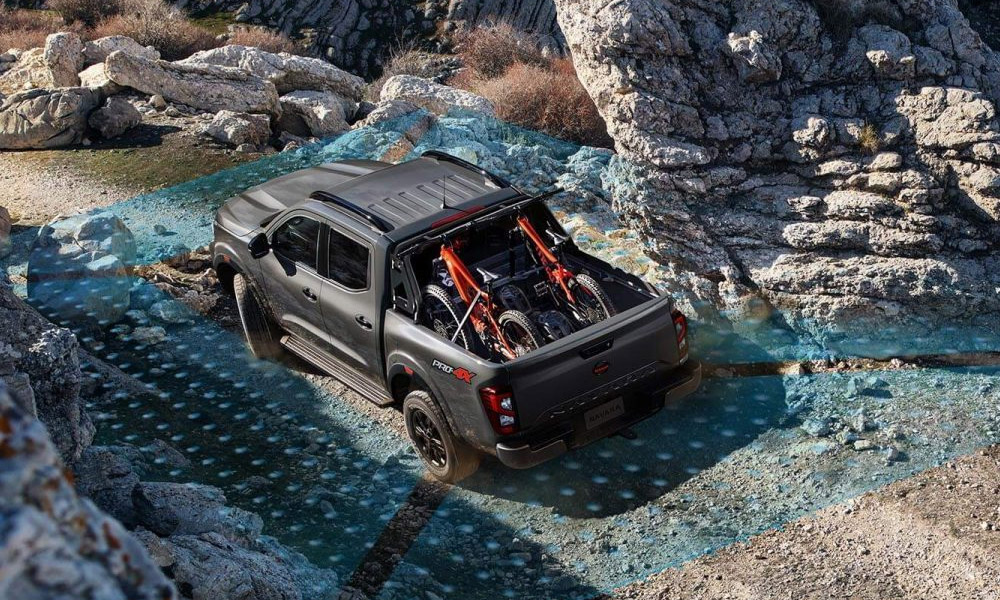 A Nissan ute driving off-road over rocks