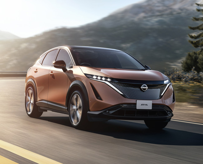 Bronze Nissan Ariya car driving on a road