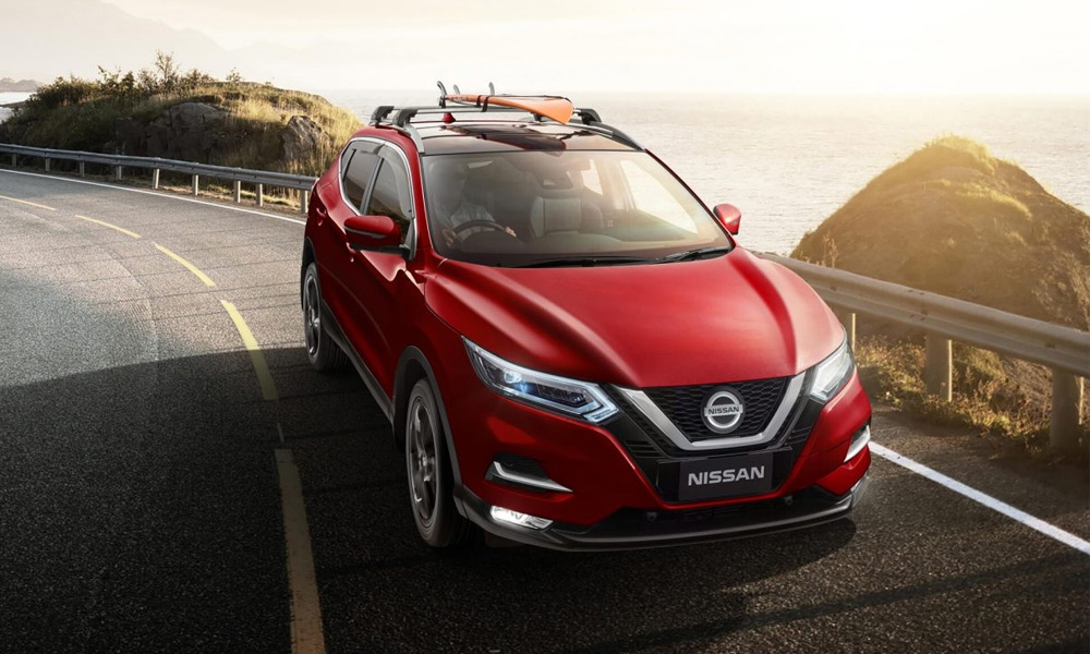 A red X-Trail SUV parked at sunset